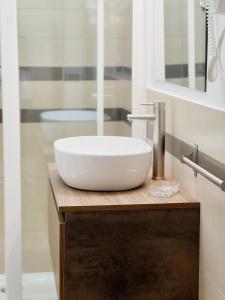 a bathroom with a white sink on a wooden counter at Scabi Apartments in Trapani +44 photos