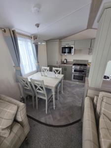 a kitchen and dining room with a table and chairs at 8 Berth Caravan - Blue Dolphin - Filey in Gristhorpe