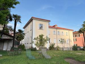 a building with chairs and tables in a yard at Bed & Blessing / Casa Borgo in Locarno