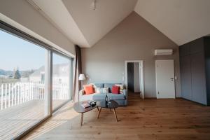 a living room with a blue couch and a large window at RELAX APARTMENTS An der Lage Hochgraßnitzberg in Spielfeld