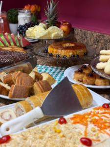 a table full of different types of bread and pastries at Domus Hotel Trindade - Canaã dos Carajás in Canaã dos Carajás