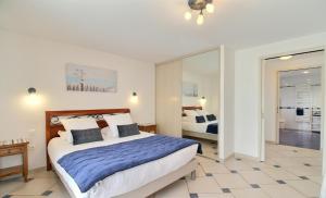 a bedroom with a large bed and a mirror at Gite de Kerantum in Mahalon