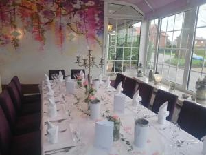 a long table with white tables and chairs with flowers at Gasthof Uthmann in Bad Iburg