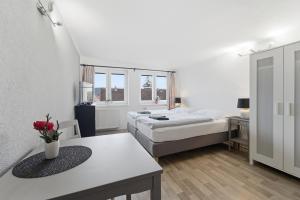 a bedroom with two beds and a table with flowers on it at Apartmán Plasy in Plasy