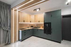 a kitchen with black appliances and wooden cabinets at Pe Coastă in Cozăneşti