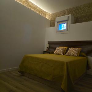 a bedroom with a bed with a television on the wall at Casa a Figueira in Pungín