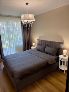 a bedroom with a large bed and a chandelier at Luxury Apartment Sofia in Sofia