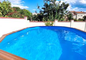 a large blue swimming pool in a backyard at Guest House - Heaven in Byala