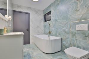 a bathroom with a tub and a toilet and a sink at Pe Coastă in Cozăneşti +17 photos