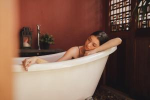 Eine Frau liegt in einer Badewanne. in der Unterkunft House Of PaPa Bangkok Siam in Bangkok + 92 Fotos