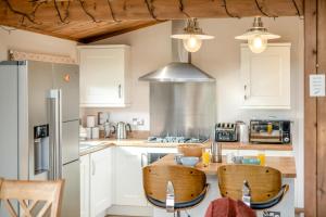 a kitchen with white cabinets and a table with chairs at 3 Bed in Whitby oc-wa057 in Runswick