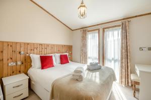 a bedroom with two beds with red pillows at 3 Bed in Whitby oc-wa057 in Runswick