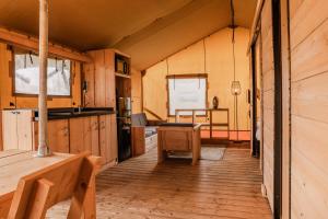 a kitchen with wooden cabinets and a desk in a cabin at Vakantiepark Eigen Wijze in Bant
