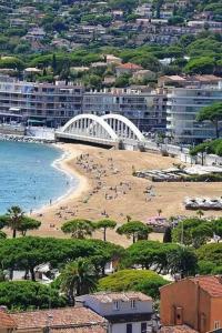 a beach with a bridge and people on it at T3 spacieux,2chambres,clim,piscine in Sainte-Maxime