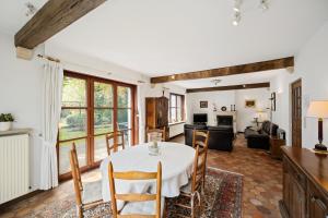 a dining room with a table and chairs and a living room at Bretoenselaan 5 in De Haan