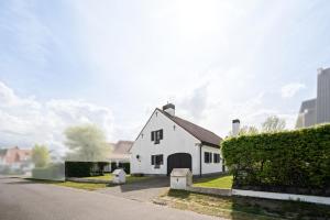 a white house on the side of a street at Bretoenselaan 5 in De Haan
