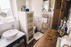 a bathroom with a white sink and a toilet at Coachman's Cottage B & B in Plymouth +9 photos