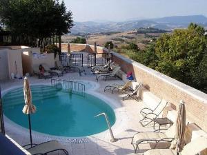 a large swimming pool with chairs and avisor at Casa Oliva borgo del Benessere delle Marche in Bargni