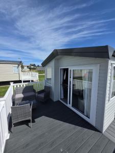 a covered deck with a couch and chairs on it at 8 Berth Caravan - Blue Dolphin - Filey in Gristhorpe