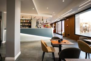 a restaurant with a table and chairs and a large screen at Hotel Art Village in Casoria