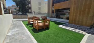 a row of wooden benches on grass in a building at Nasma Homes in Abu Dhabi