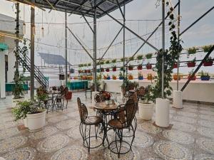 a patio with tables and chairs and plants in a building at Palette Oraya Greens by CheckIn, Kathauta Lake, Lucknow in Chinhat