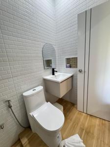 a white bathroom with a toilet and a sink at Khaosok Embrace Resort in Khao Sok National Park +26 photos
