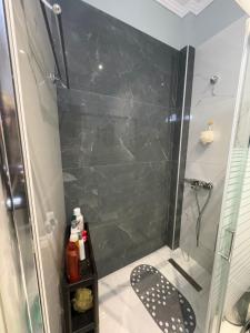 a shower with a glass door in a bathroom at Stone house 48 m in Acharnes +9 photos