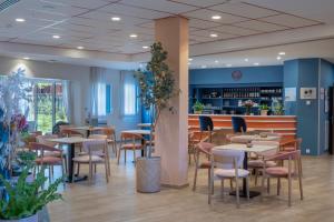 a restaurant with tables and chairs and a bar at DOMITYS - Les Aviateurs in Muret