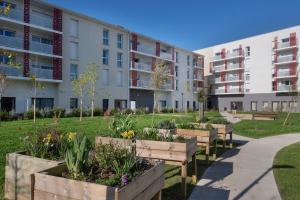 a garden in front of an apartment building at DOMITYS - Les Aviateurs in Muret