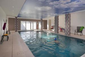a large swimming pool with a person in the water at DOMITYS - Les Aviateurs in Muret