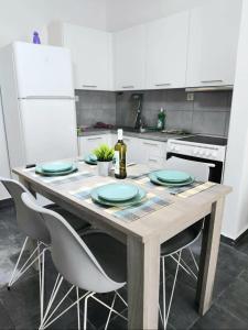 a kitchen with a wooden table with plates and chairs at Seawaves in Ierissos
