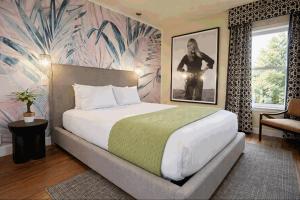 a bedroom with a large bed with a tropical wallpaper at The Crescent Hotel Beverly Hills in Los Angeles