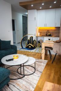 a living room with a coffee table and a kitchen at ApartmanMFoca in Foča