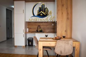 a kitchen with a wooden table and two glasses of wine at ApartmanMFoca in Foča +11 photos
