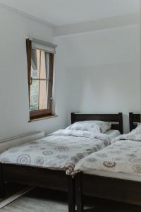 two beds in a room with a window at Schronisko PTTK Pod Muflonem in Duszniki Zdrój