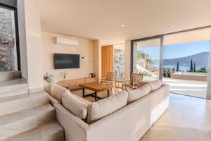 a living room with a large couch and a television at Casa Ambar Luxury Lake View Villa Pool Design in San Juan Cosalá