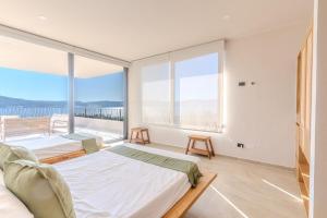 a bedroom with two beds and a large window at Casa Ambar Luxury Lake View Villa Pool Design in San Juan Cosalá