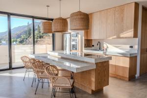 a kitchen with a counter with chairs and a counter top at Casa Ambar Luxury Lake View Villa Pool Design in San Juan Cosalá