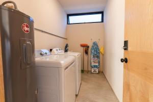 a small bathroom with a sink and a washing machine at Casa Ambar Luxury Lake View Villa Pool Design in San Juan Cosalá +40 photos
