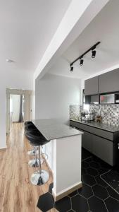 a kitchen with a counter and a bar stool at GL Luxe Suites in Tatu City