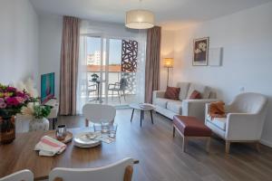 a living room with a couch and a table at DOMITYS - Les Aviateurs in Muret
