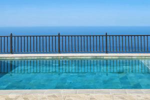 a swimming pool with a fence and the ocean at Casa Tia Rosalia in Tijarafe