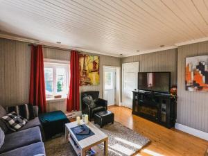 a living room with a couch and a tv at La Suite du Havre in Saint-Charles-des-Grondines