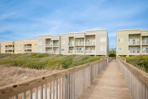 a boardwalk leading to the beach with condos at Beach Therapy by Oak Island Accommodations in Caswell Beach