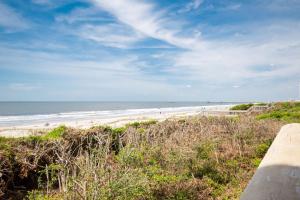a view of a beach with people in the ocean at Beach Therapy by Oak Island Accommodations in Caswell Beach