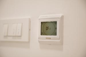 a white alarm clock on a white wall at River side apartment B17 in Herceg-Novi