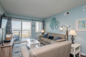 a living room with a couch and a table at Beach Therapy by Oak Island Accommodations in Caswell Beach +50 photos