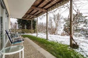 a porch with chairs and a table in the snow at Adlerhorst in Wangen