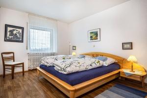 a bedroom with a bed and a chair and a window at Adlerhorst in Wangen